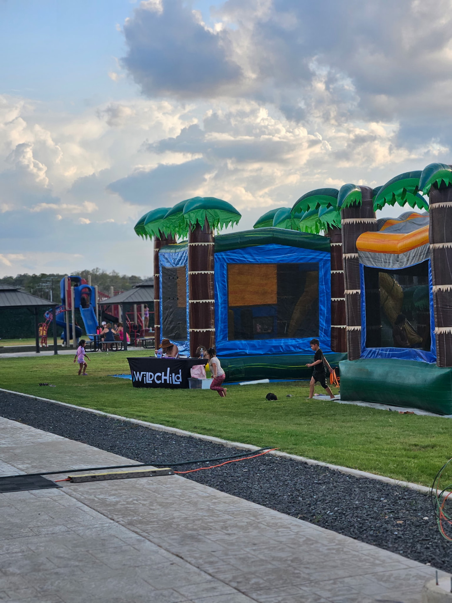 Tropical bounce houses on the lawn at dusk during Family Fun Day