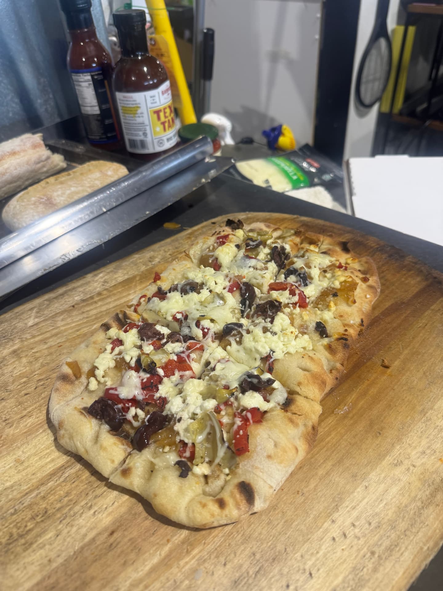 Fresh flatbread with feta, olives, and roasted peppers