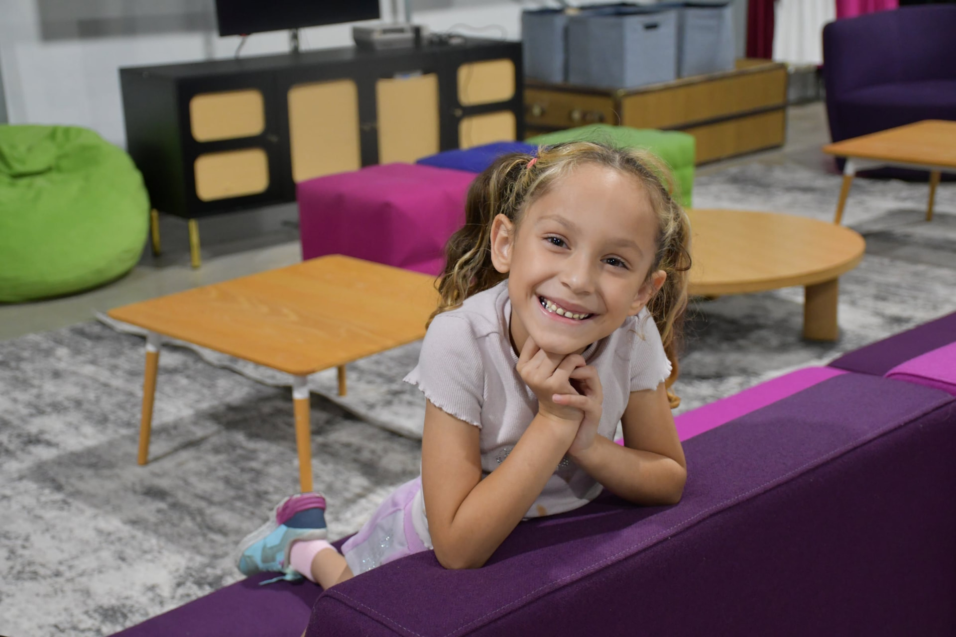 Smiling child in the colorful kids lounge at Hyperloop Plaza