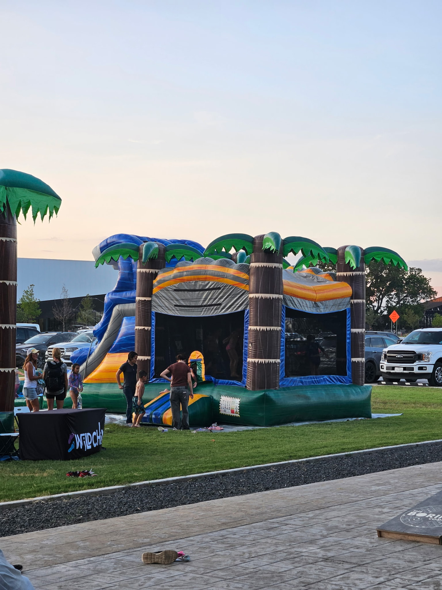 Inflatable water slide and bounce house at sunset on the plaza lawn