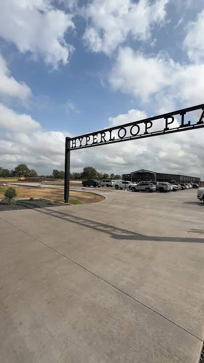 Hyperloop Plaza entrance sign under a Texas sky